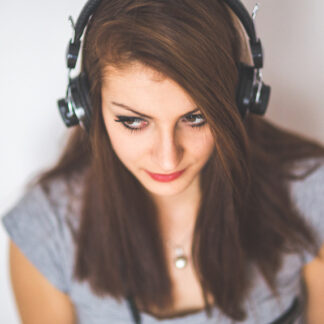 close-up photo of a woman wearing headphones