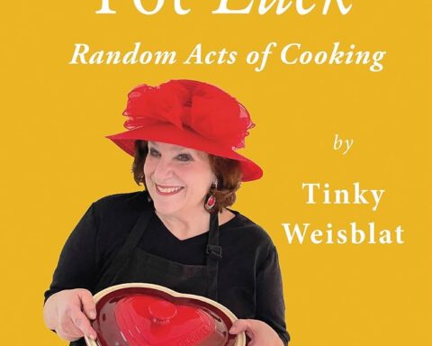 Cover of the book Pot Luck: Random Acts of Cooking by Tinky Weisblat. The background is a bright, jaunty yellow. The title appears in large white serif lettering at the top. Below it, Tinky Weisblat is pictured smiling, wearing a black knit top and a black apron. She holds a red, heart-shaped casserole dish in front of her. Her name appears at the bottom of the cover in smaller white text.