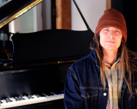 Vermont musician, radio host, and recovery advocate Benjamin Lerner sits beside a grand piano ahead of his 24-hour CLEAN Jam radiothon celebrating 10 years of sobriety.