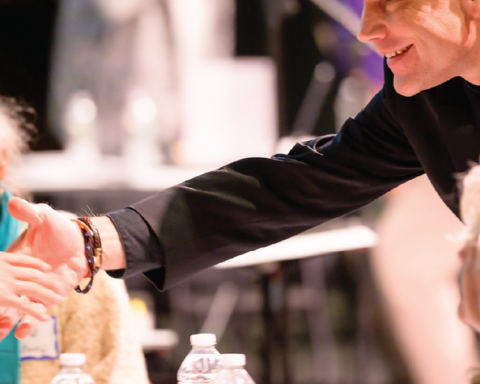 Participants greet one another during an Adams Theater MA250 Festival program image.