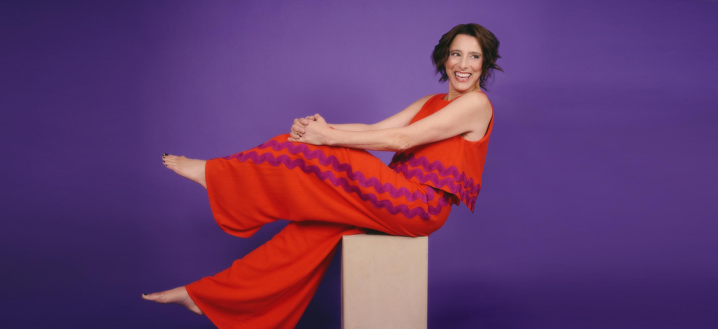 Judy Kuhn reclining in a red dress in promotional portrait for Barrington Stage Company cabaret performance in Pittsfield