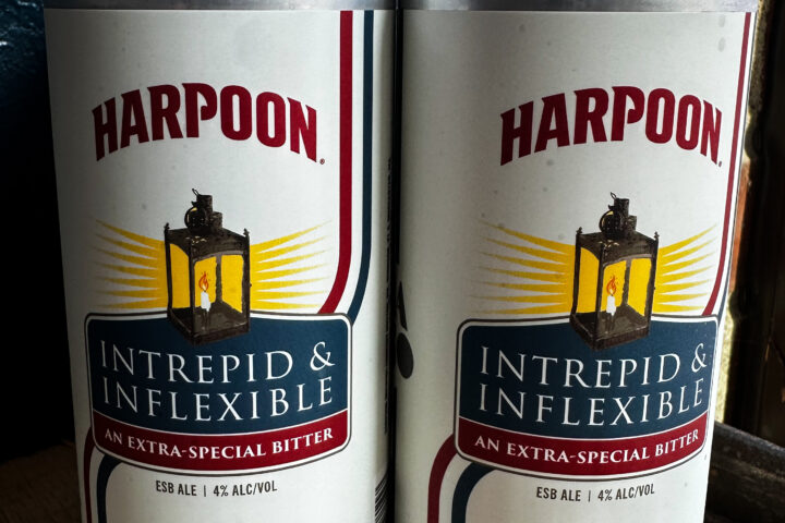 Two cans of Hot Plate Brewing Co.'s Intrepid & Inflexible Extra Special Bitter stand side by side. Brewed in collaboration with Harpoon Brewery, the Colonial-inspired ale was created to mark the 250th anniversary of American independence.