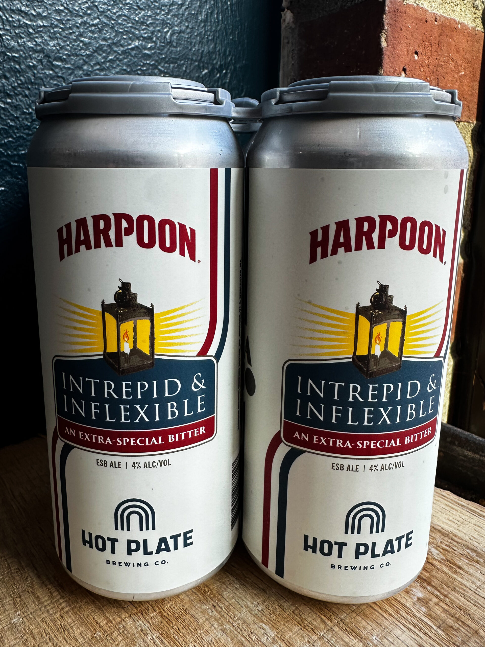 Two cans of Hot Plate Brewing Co.'s Intrepid & Inflexible Extra Special Bitter stand side by side. Brewed in collaboration with Harpoon Brewery, the Colonial-inspired ale was created to mark the 250th anniversary of American independence.